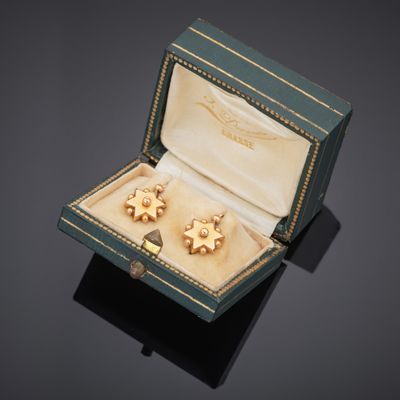 an image of a pair of earrings in a box on a black surface