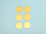 four gold coins are arranged in a row on a blue surface