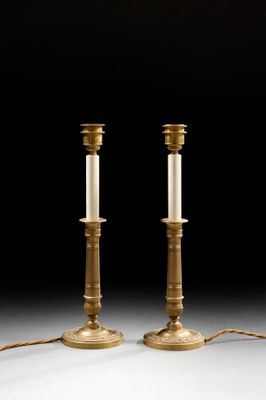 a pair of brass candlesticks with candles on each of them