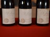 three bottles of wine sitting on a table next to each other