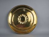 a gold plate with a circular design on it
