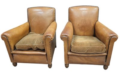 deux fauteuils en cuir marron, ornés de coussins, sur fond blanc