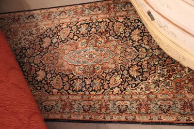 a large rug on the floor next to a dresser