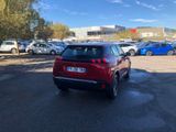 the red car is parked in a parking lot with other cars