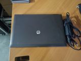hp laptop with charger and power cord sitting on a wooden table