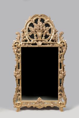 une image représentant un miroir doré sur fond noir, avec une horloge en arrière-plan