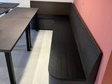 a long table with a bench in the corner of the room