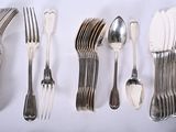many forks and spoons laid out on the table