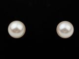une paire de boucles d'oreilles en perles blanches sur fond noir