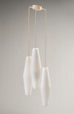 trois vases blancs suspendus à une ficelle sur un mur gris
