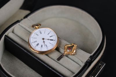 a watch in a case with a key in it