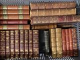 de nombreux livres anciens dans un panier en métal posé sur l'étagère