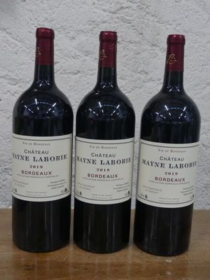 trois bouteilles de vin posées sur une table en bois