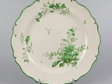 une assiette verte et blanche décorée de fleurs et de feuilles
