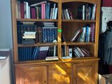 a wooden bookcase with many books on it in a room