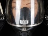 a woman wearing a gas mask and helmet on a motorcycle
