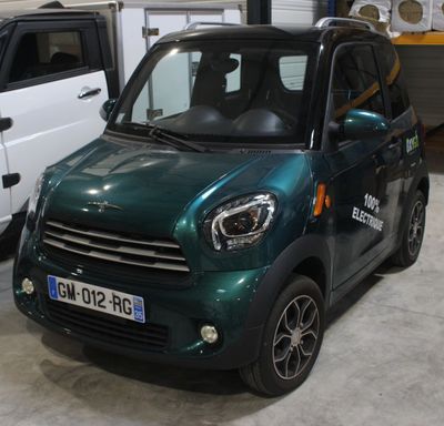 deux petites voitures garées l'une à côté de l'autre dans un garage