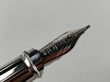 the tip of a fountain pen with a silver nib and a black nib