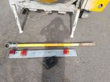 a yellow wheel on the ground next to a yellow machine