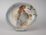une assiette bleue et blanche sur laquelle est représenté un coq