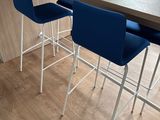 three blue chairs sitting at a table with a red, white, and blue flag on it