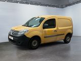 La camionnette jaune est garée dans une grande pièce aux murs blancs.