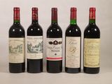 quatre bouteilles de vin rouge sont alignées sur une table