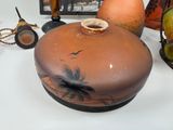 a brown vase sitting on top of a table next to other vases