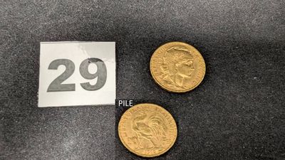 Deux pièces d'or portant le chiffre 29 sont posées à côté d'une étiquette de prix