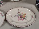 four plates with flowers on them sitting on a table