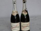 two bottles of champagne sitting on a marble table