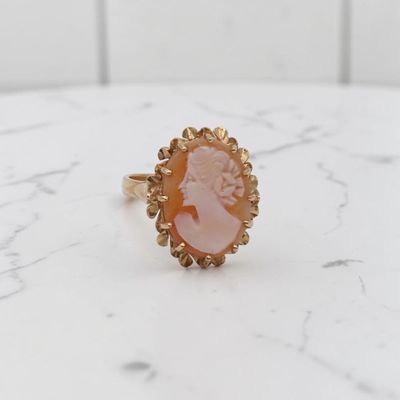 un gros plan d'une bague en or ornée d'une pierre rose au centre