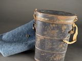 an old metal bucket with a blue bag on it