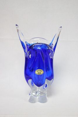 un vase en verre bleu contenant une fleur bleue
