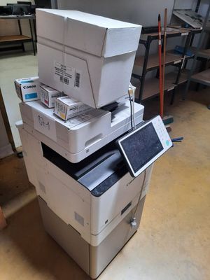 une pile d'imprimantes empilées les unes sur les autres dans une pièce