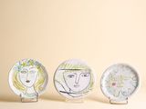 trois assiettes ornées de dessins sont posées sur une table