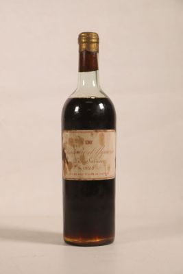 an old bottle of liquor sitting on top of a white surface
