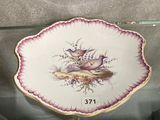 a plate with a bird on it on display in a glass case