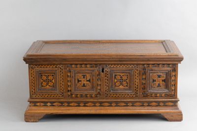 un vieux coffre en bois orné de panneaux sculptés et doté de tiroirs sur le dessus