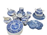 des assiettes, tasses et soucoupes en porcelaine bleue et blanche sur fond blanc