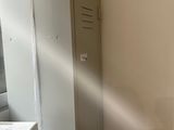 a metal locker in the corner of a small room