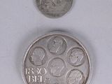 a silver coin and a silver coin on a white surface