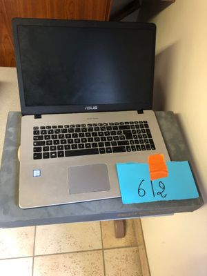 a laptop computer sitting on a desk with a note on it