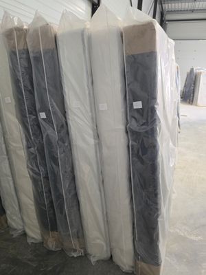 de nombreux matelas empilés dans un grand entrepôt