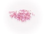 a pile of pink crystals on a white surface