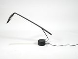 the black lamp is on a white surface with a black cord