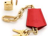 a red leather keychain with a padlock and two keys attached to it