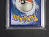 a pokemon card in a plastic case on a table
