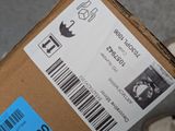 a box with a barcode on it sitting on a person ' s feet