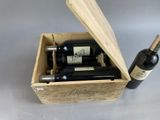 a wooden box with two bottles of wine inside of it